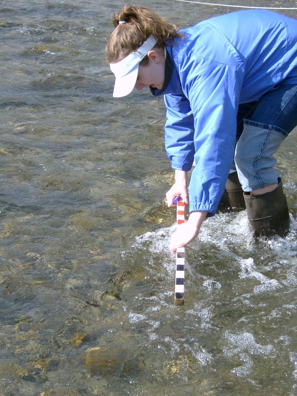 student preparing float experiment in stream