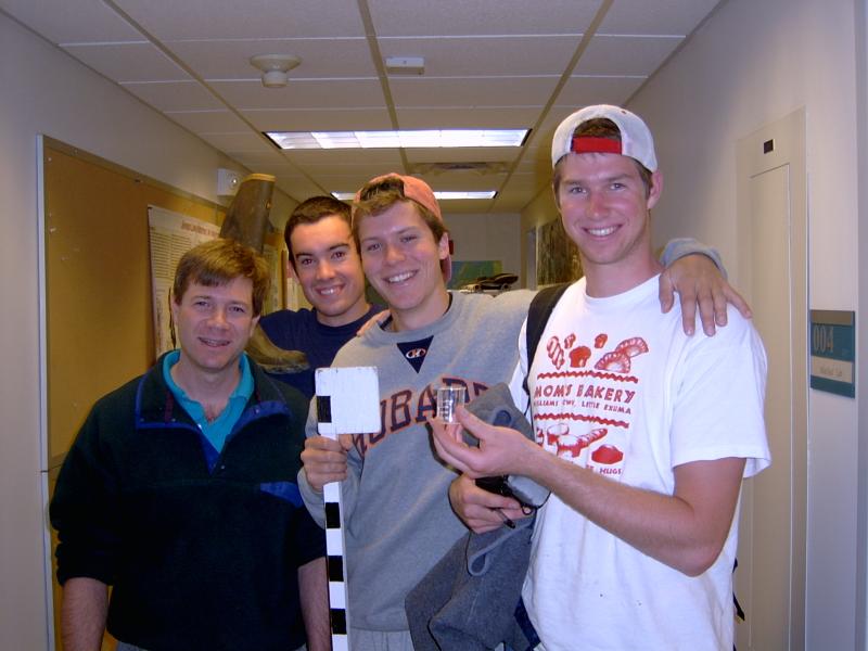 Four people posing in hallway